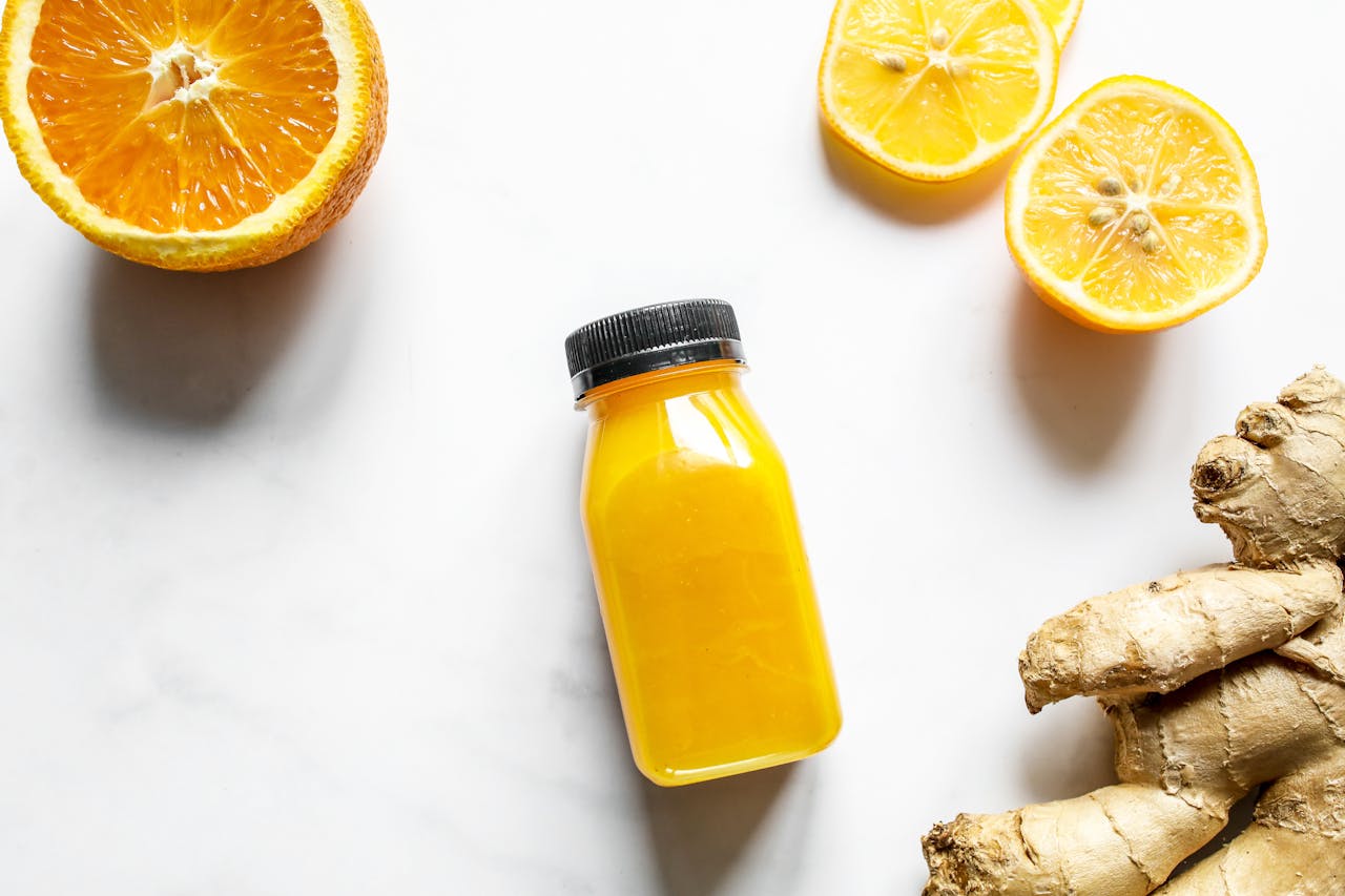 Assortiment coloré d'aliments anti-inflammatoires comprenant des baies, de l'ail, du curcuma, des agrumes, des légumes verts, des noix et du poisson gras, disposés sur une table en bois.