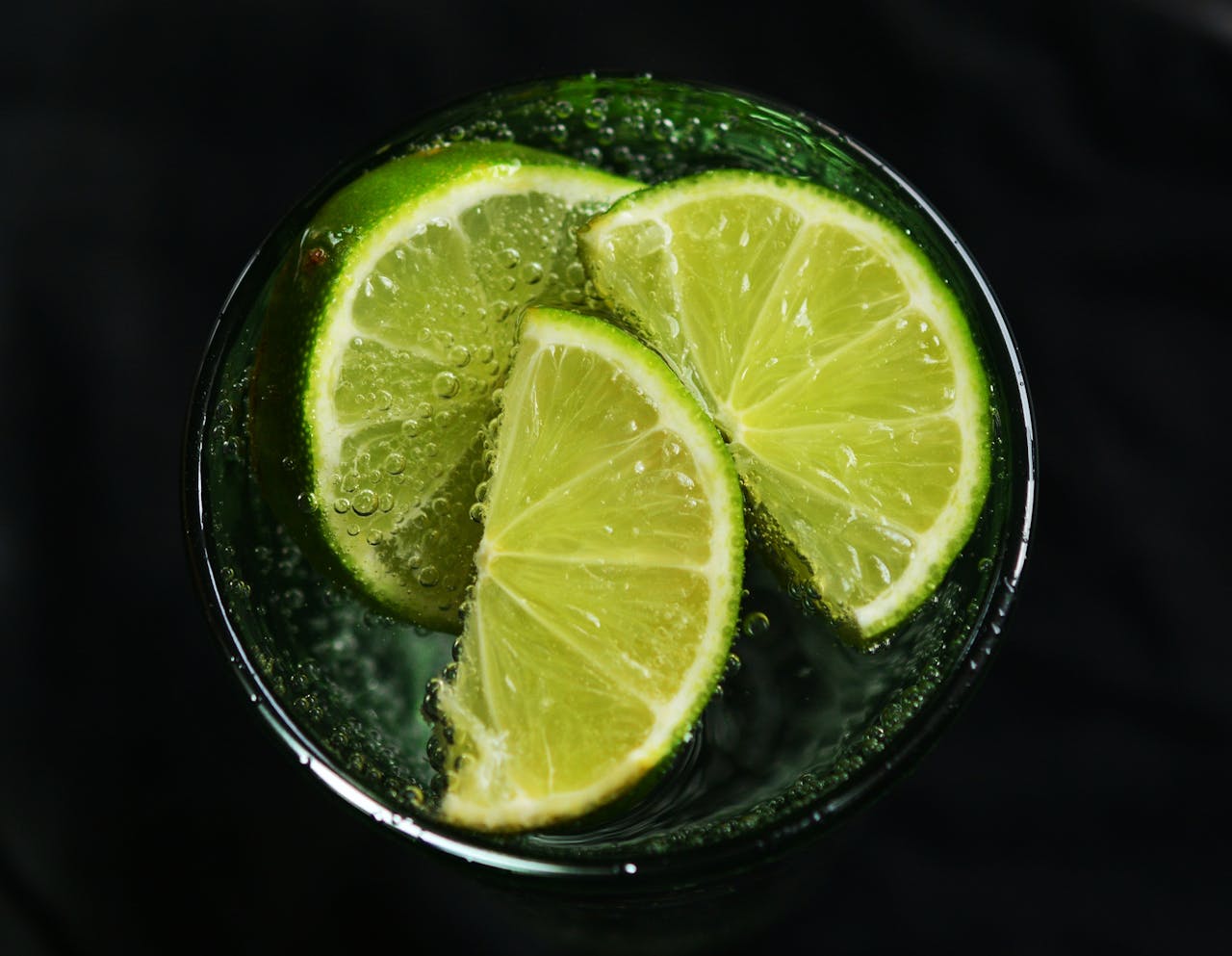 Verre d’eau tiède avec une tranche de citron posé sur une table au réveil, illustrant l’habitude matinale de boire de l’eau citronnée pour la digestion et l’immunité.
