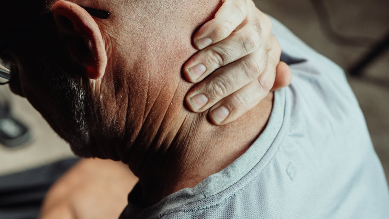 Illustration d’une personne stressée tenant sa tête entre ses mains, entourée d’icônes représentant l’anxiété, la fatigue, les troubles du sommeil et la douleur, sur fond clair.