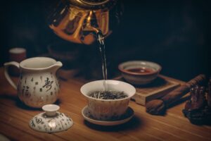 Tasse de tisane chaude entourée de plantes apaisantes comme la camomille et la lavande, idéale pour favoriser le sommeil naturellement.